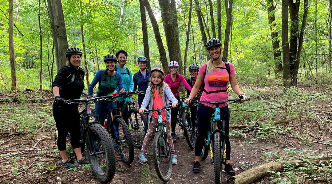 Group of Mountain Bikers on wooded mountain bike trail.