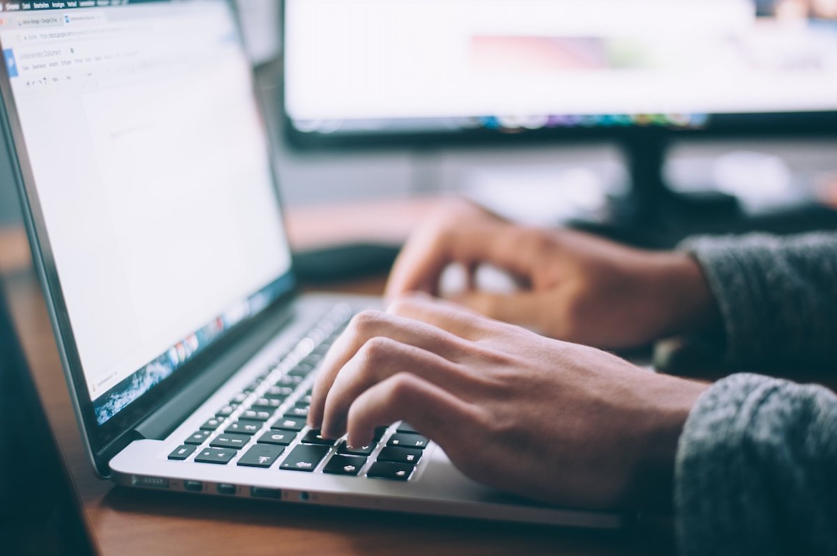 Man typing on a laptop computer.